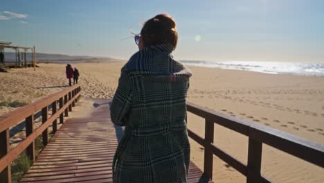 handheld shot of woman walking at the beach path