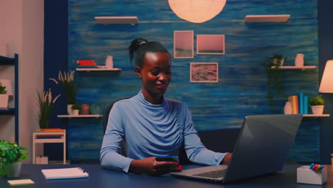 black business woman making transaction from home using credit card