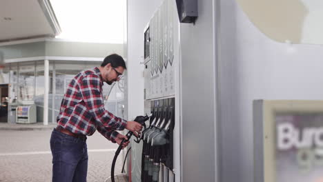 man filling car at gas station
