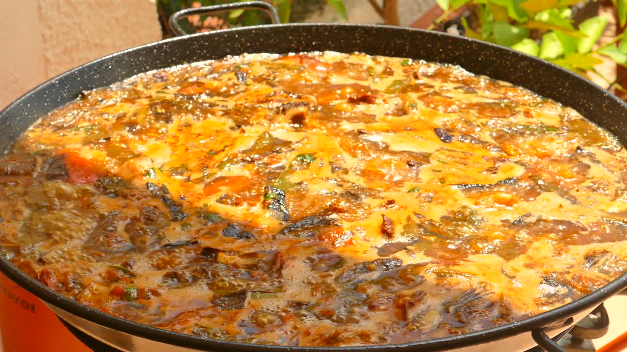 스페인 발렌시아에서 낮에 전통적인 팬에서 요리되고 있는  ⁇ 과  ⁇ 고기와 함께 전통적인 파엘라의 근접 촬영