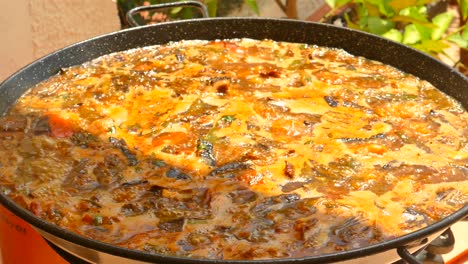 Primer-Plano-De-Paella-Tradicional-Con-Arroz-Y-Pollo,-Cocinada-En-Sartén-Tradicional-En-Valencia,-España-Durante-El-Día