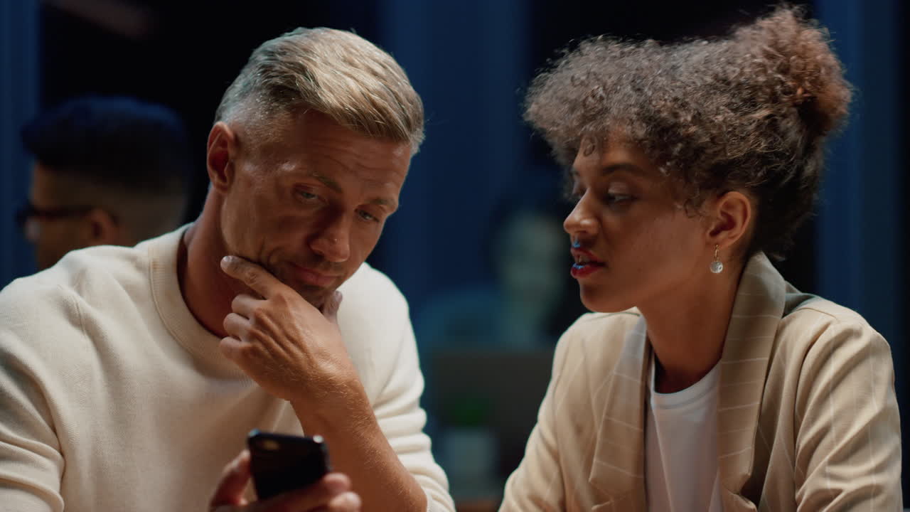 카페에서 비즈니스 회의에서 스마트폰을 사용하는 사업가와 사업가