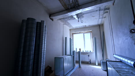 ductwork install at construction site. a room under construction showcases metal ductwork and exposed walls with a large window letting in natural light