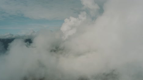 drone aerial flying next to puffy clouds, top landscape panoramic view