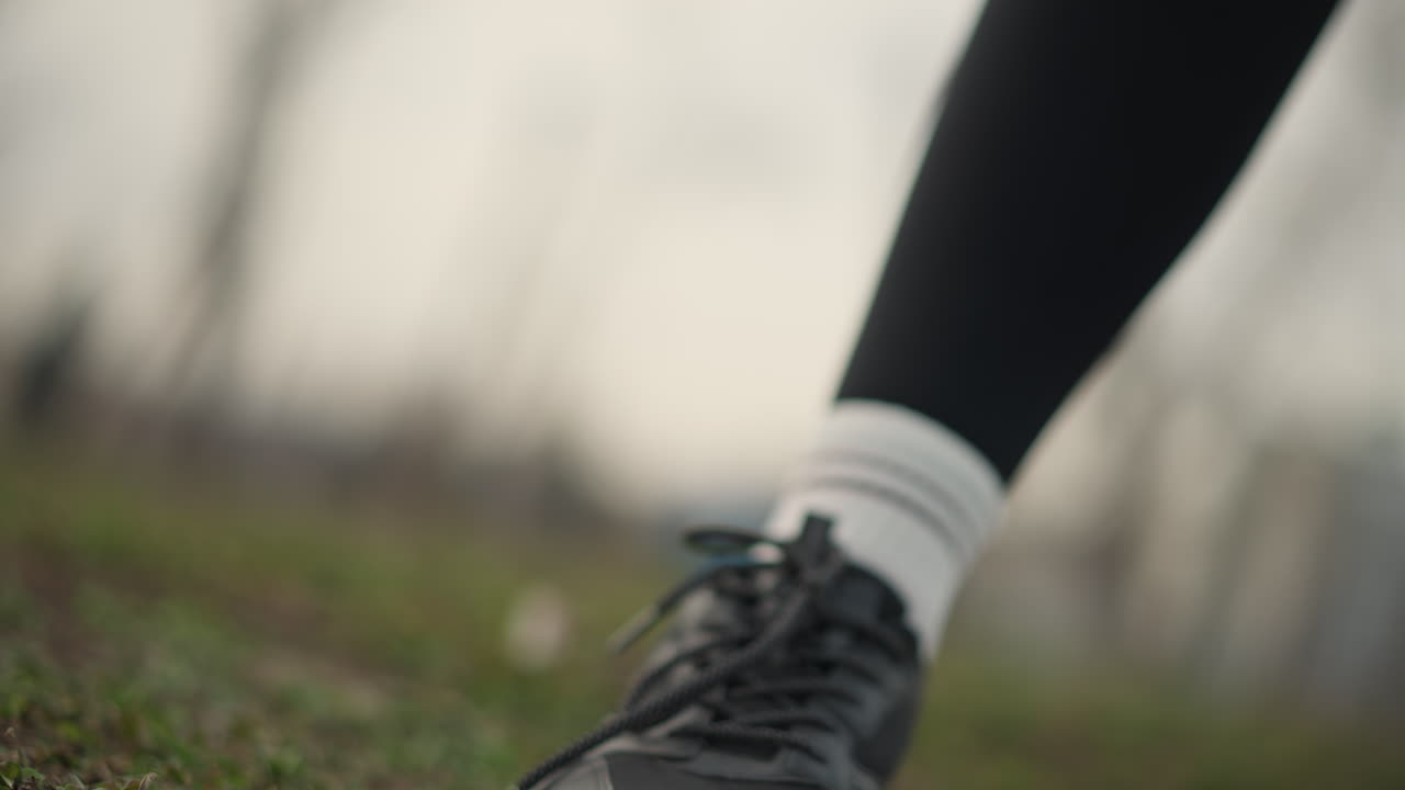 Close Examination Of Athletic Shoe And Hands, Detailed Image Of Hands Grasping Sport Shoe On Grass, Focused Shot Showing Hands Clutching Sneaker With Textured Sole On Grassy Terrain