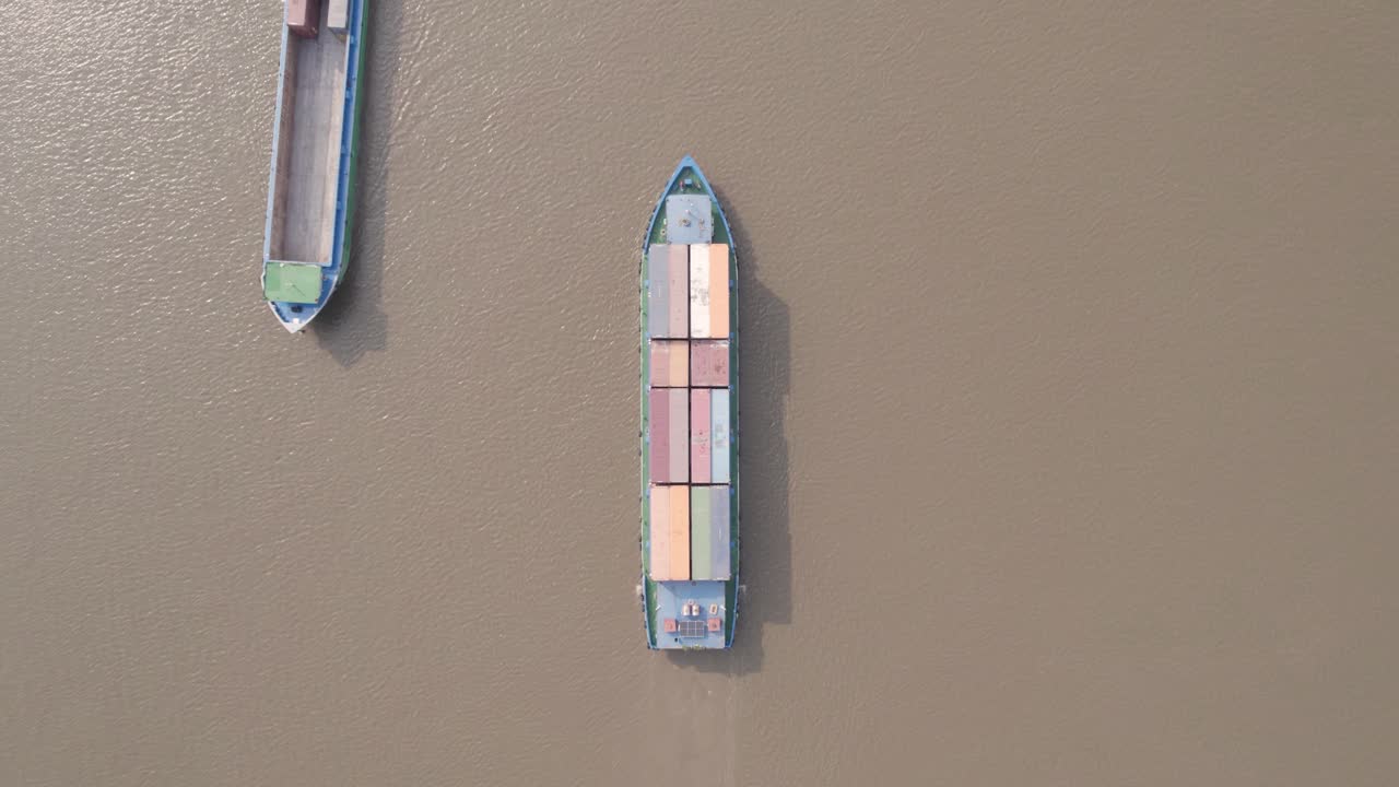 다른 배가 지나가는 강에서 물류 운송 컨테이너 선박의 위에서 아래로 볼 수 있습니다.