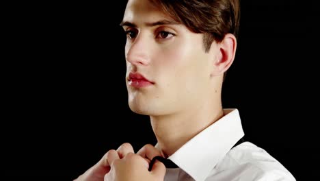 androgynous man adjusting bow tie