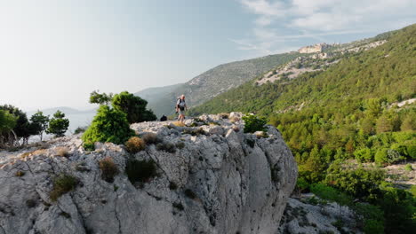 Der-Wanderer-Steigt-Zum-Atemberaubenden-Aussichtspunkt-Von-Lubenice-In-Kroatien-Hinauf-Und-Steht-Fest,-Um-Die-Malerische-Aussicht-Auf-Die-Berge-Zu-Genießen