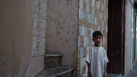 young boy standing by a staircase