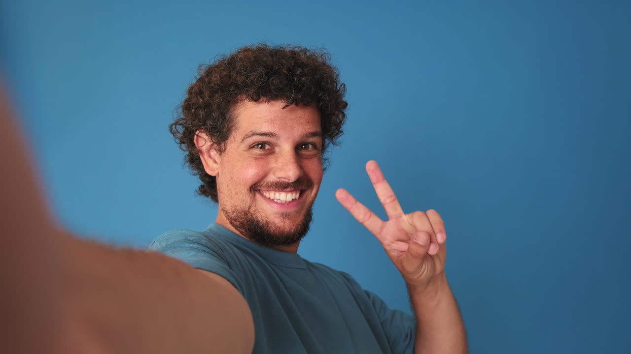 Uomo felice che si scatta un selfie e mostra il segno della pace