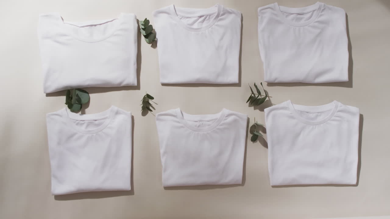 video de una capa plana de camisetas blancas plegadas con espacio de copia sobre un fondo blanco