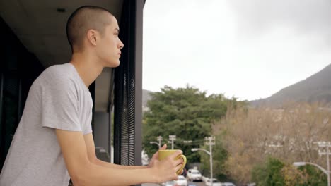 man holding coffee cup while standing in balcony 4k