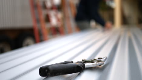 a pair of sheet metal tin snips on building materials at a construction site