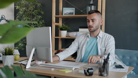 man working on architectural plans in a home office