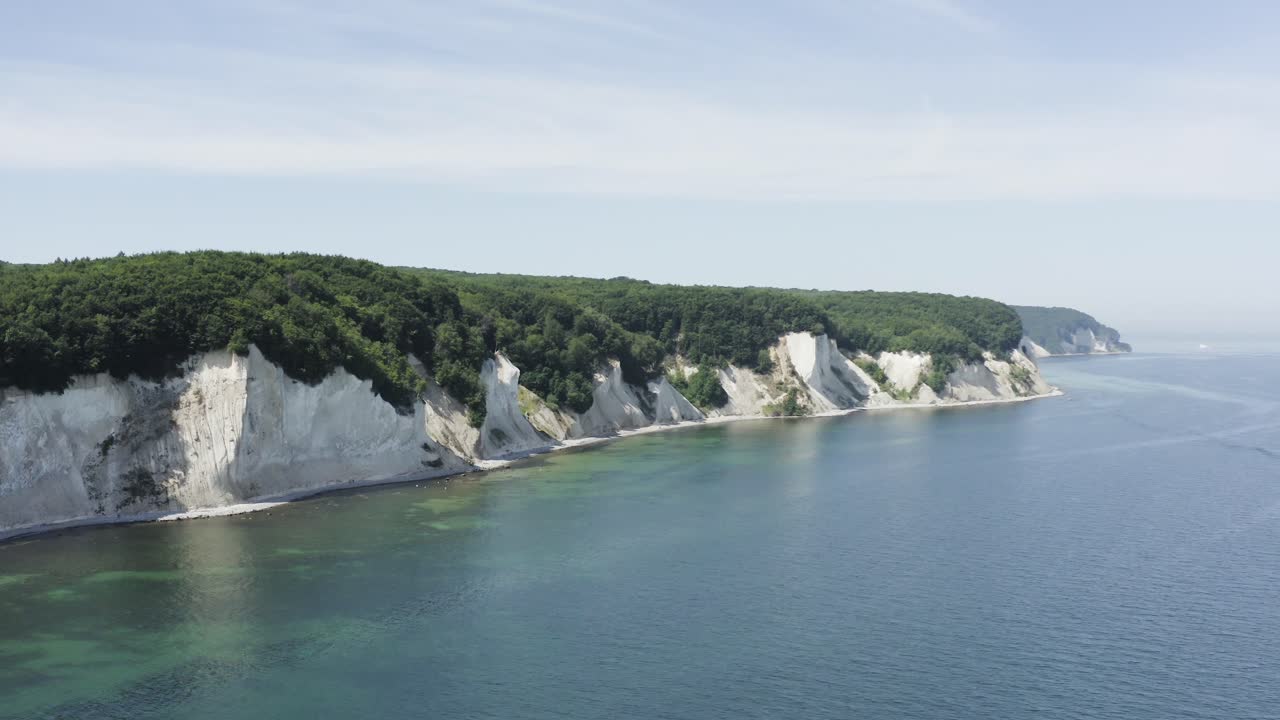 Ripresa aerea con drone delle falesie di gesso sull'isola di Rügen in Germania, con una luce splendida e acqua di mare verde e blu, Europa