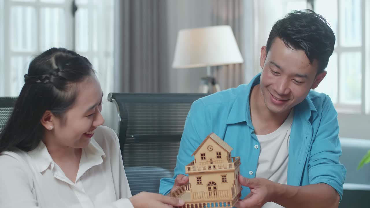 행복 한 부부 가 모형 집 을 보고 있다