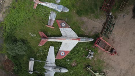 Aerial-shot-of-an-abandoned-RAF-aircraft-graveyard-in-England-with-De-Havilland-Vampire,-Gloster-Meteor,-F