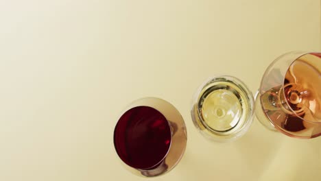 diversos tipos de vinos en vasos en superficie amarilla con espacio de copia