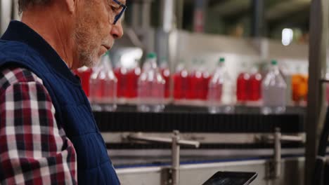 worker using digital tablet in bottle factory