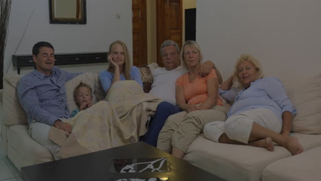 big family watching tv in the evening