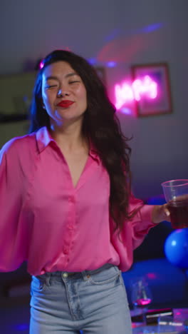 Vertical-Video-Of-Long-Haired-Woman-Having-Fun-Dancing-And-Drinking-Alcohol-At-House-Party-3