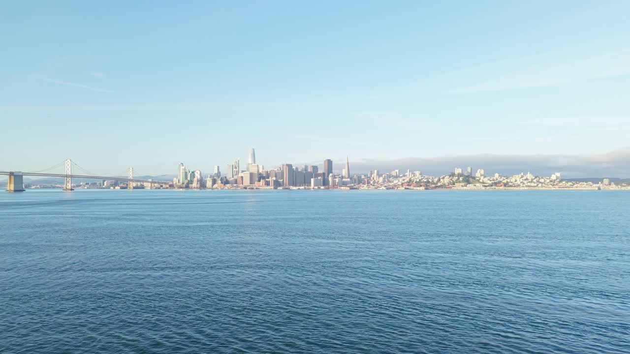 A slow zoom out view of the San Francisco Bay Bridge and Embarcadero in the distance.