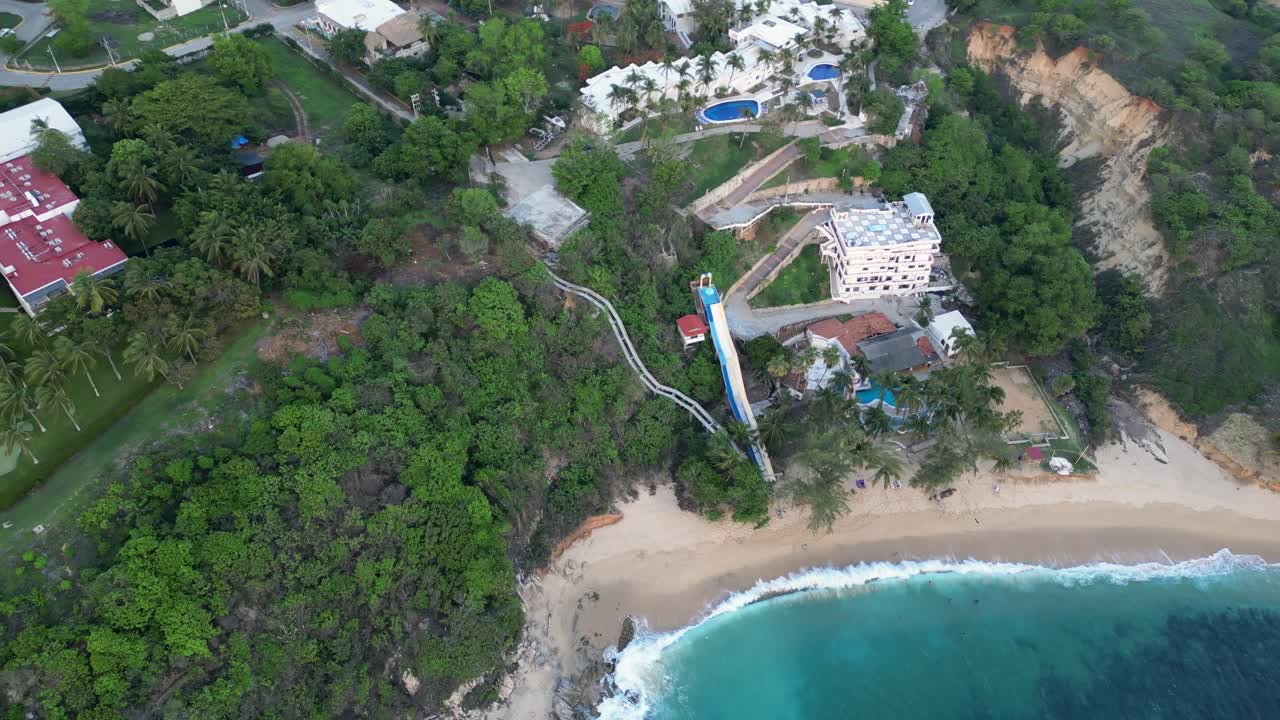 video de drones de la playa de coral, su exuberante vegetación y naturaleza, junto con las residencias y hoteles encaramados en las montañas circundantes en puerto escondido, oaxaca, méxico