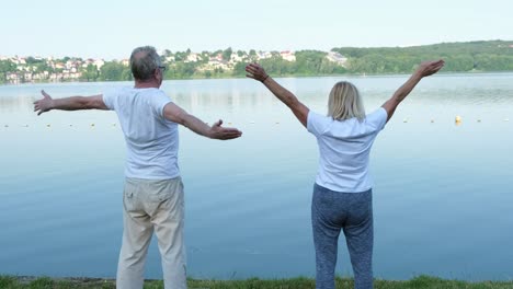 happy elderly european family doing morning exercise by the lake happy elderly european family doing morning exercise by the lake the concept of a healthy life in retirement age