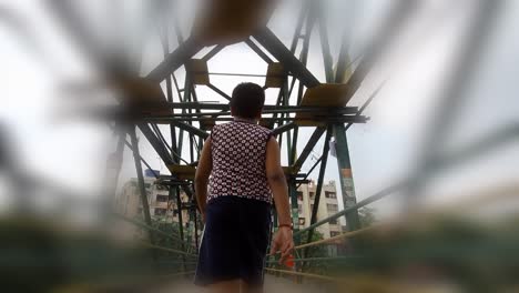 little kid walks on bridge in dream or nightmare on cloudy day, low angle from behind