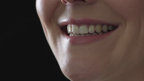 close up woman mouth smiling happy beautiful soft lips showing healthy teeth on black background