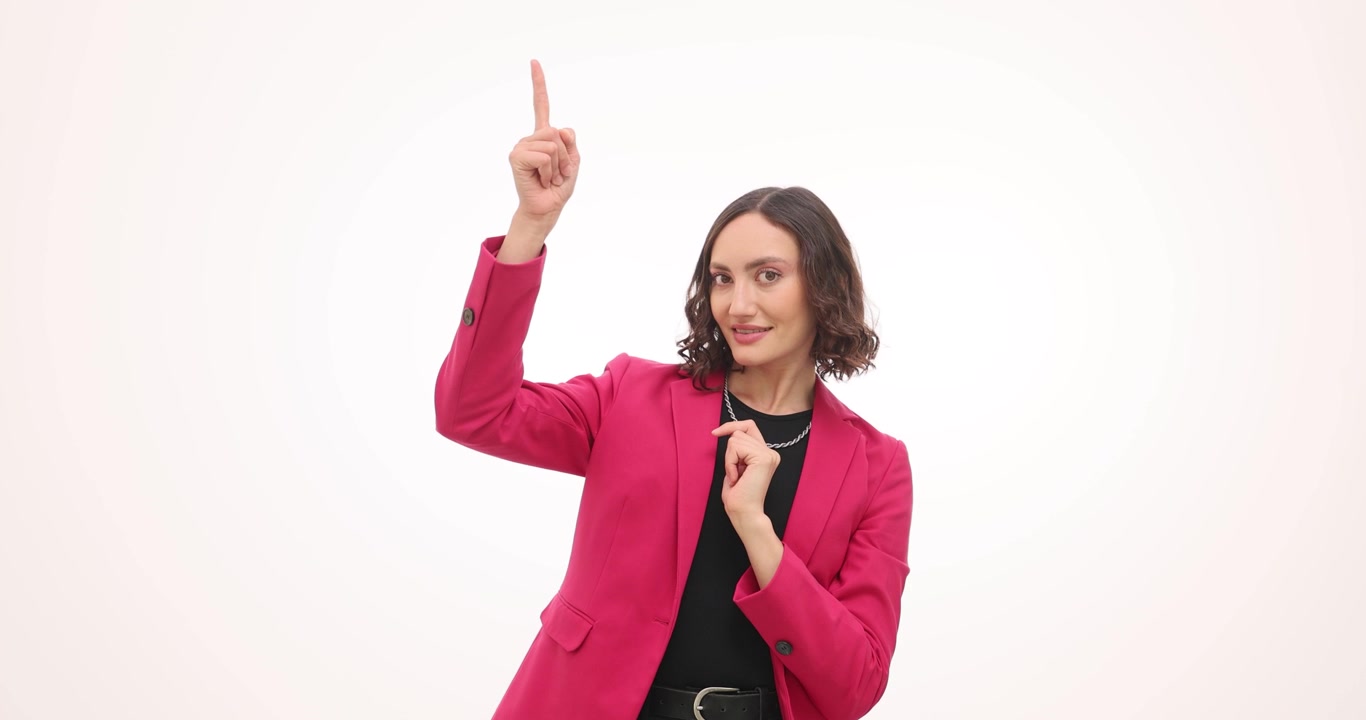 Donna in blazer rosso scarlatto acceso sorride e punta il dito verso l'alto