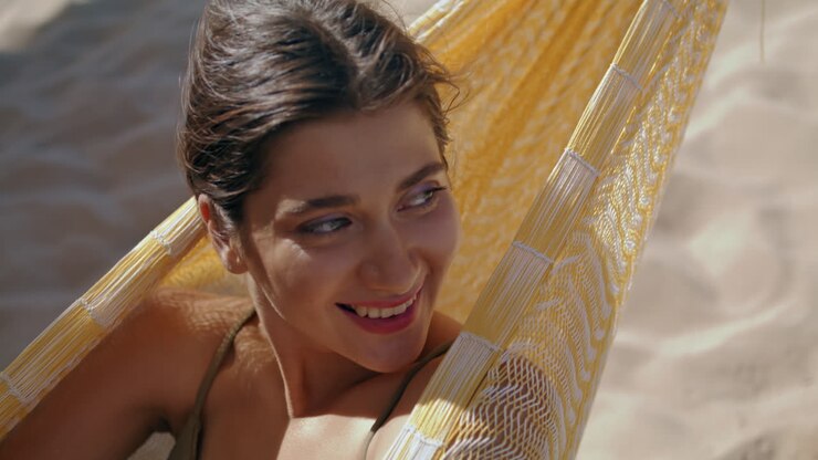 Woman chilling hammock beach alone portrait. Smiling beautiful girl closing eyes