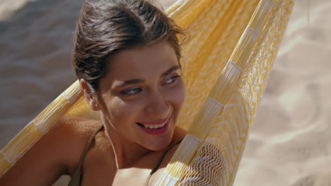 mujer chilling hamaca playa sola retrato. sonriente hermosa chica cerrando los ojos