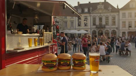 delicious triple cheeseburgers with fresh ingredients served at a vibrant food truck gathering amidst a lively outdoor crowd with refreshing beverages