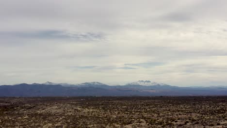 Inclinación-Aérea-Hacia-Abajo-Desde-Las-Montañas-Nevadas-De-Los-Mazatzals-Hasta-El-Desierto-Desierto-De-Sonora,-Scottsdale,-Arizona