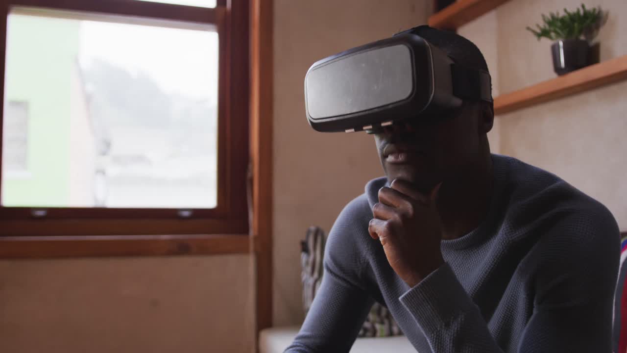 African American man wearing VR headset at home
