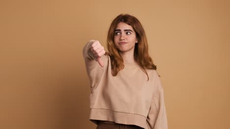 young woman gesturing disagreement with thumb down