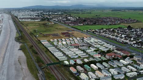 Static-caravan-trailer-beachfront-staycation-holiday-home-campground-resort-aerial-view-descending-birdseye-shot