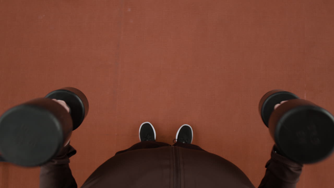 Overhead view of a person holding dumbbells during a workout