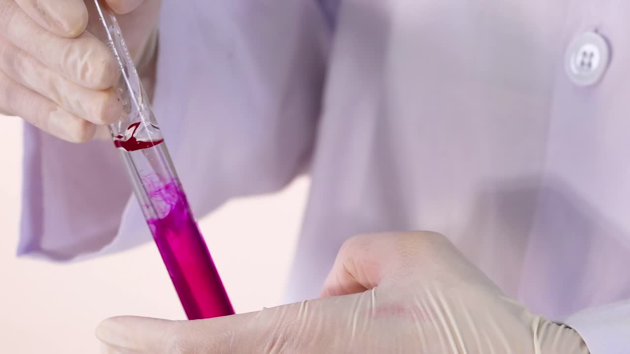 A gloved hand performs a liquid reaction in a test tube, showcasing a vivid color change.