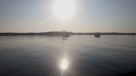 traveling by boat at the sea passing by fornells in menorca, spain on a sunny summer day