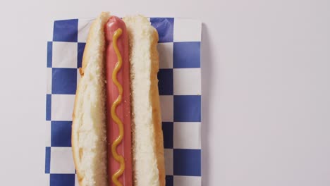 Video-of-hot-dog-with-mustard-on-a-white-surface