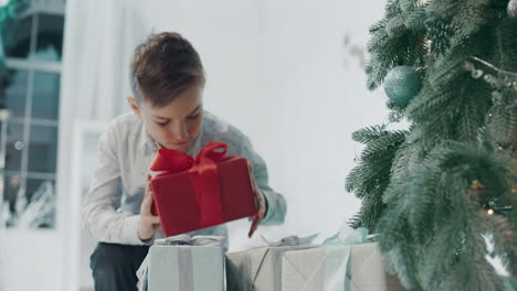 Nahaufnahme-Eines-Jungen-Mannes,-Der-Ein-Geschenk-In-Der-Nähe-Des-Weihnachtsbaums-In-Einem-Luxushaus-Entgegennimmt.