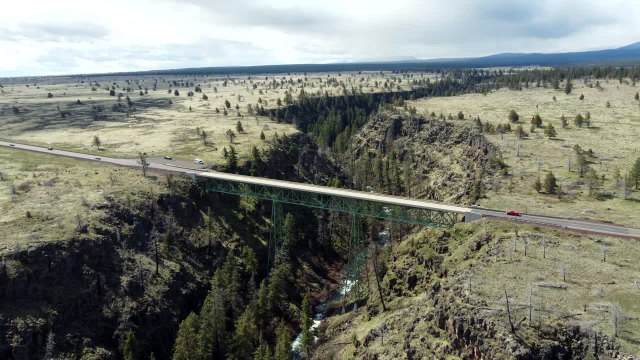 Drone view of a steel bridge crossing Highway 26 over Mill Creek in a gorge-canyon in central Oregon in spring