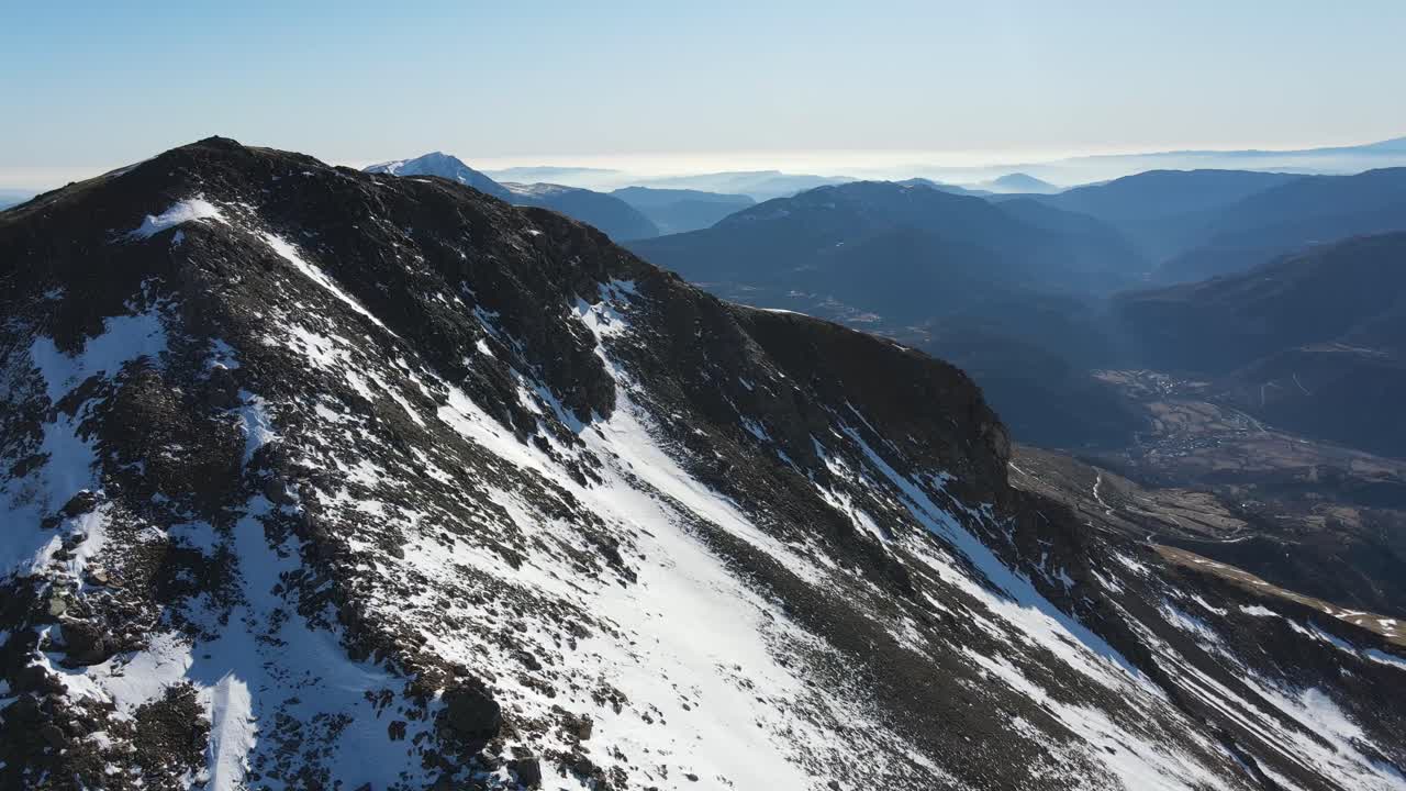Splendida vista panoramica aerea di un paesaggio montano innevato nei Pirenei durante una soleggiata giornata invernale.