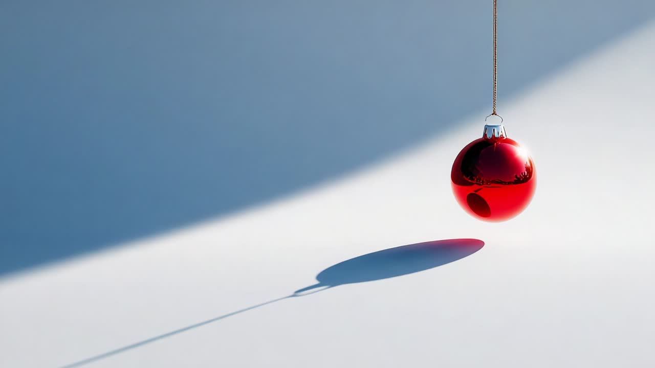 A Beautifully Captivating Red Christmas Ornament Suspended in Midair, Casting a Delicate Shadow on a Softly Lit Surface, Evoking Festive Cheer and Seasonal Warmth for a Magical Holiday Atmosphere