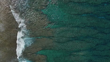 Waves-along-a-tropical-beach---straight-down-view-in-vertical-orientation