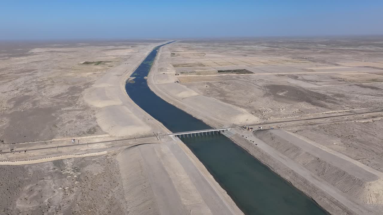 Aerial drone view circling a bridge on the Amudarja river canal, in sunny Balkh, Afghanistan