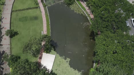 aerial-view-of-modern-urban-park-featuring-lakes,-lush-gardens,-bridges,-green-space,-pathways-and-trees