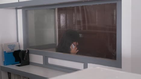 asian women answer phone call in isolated booth